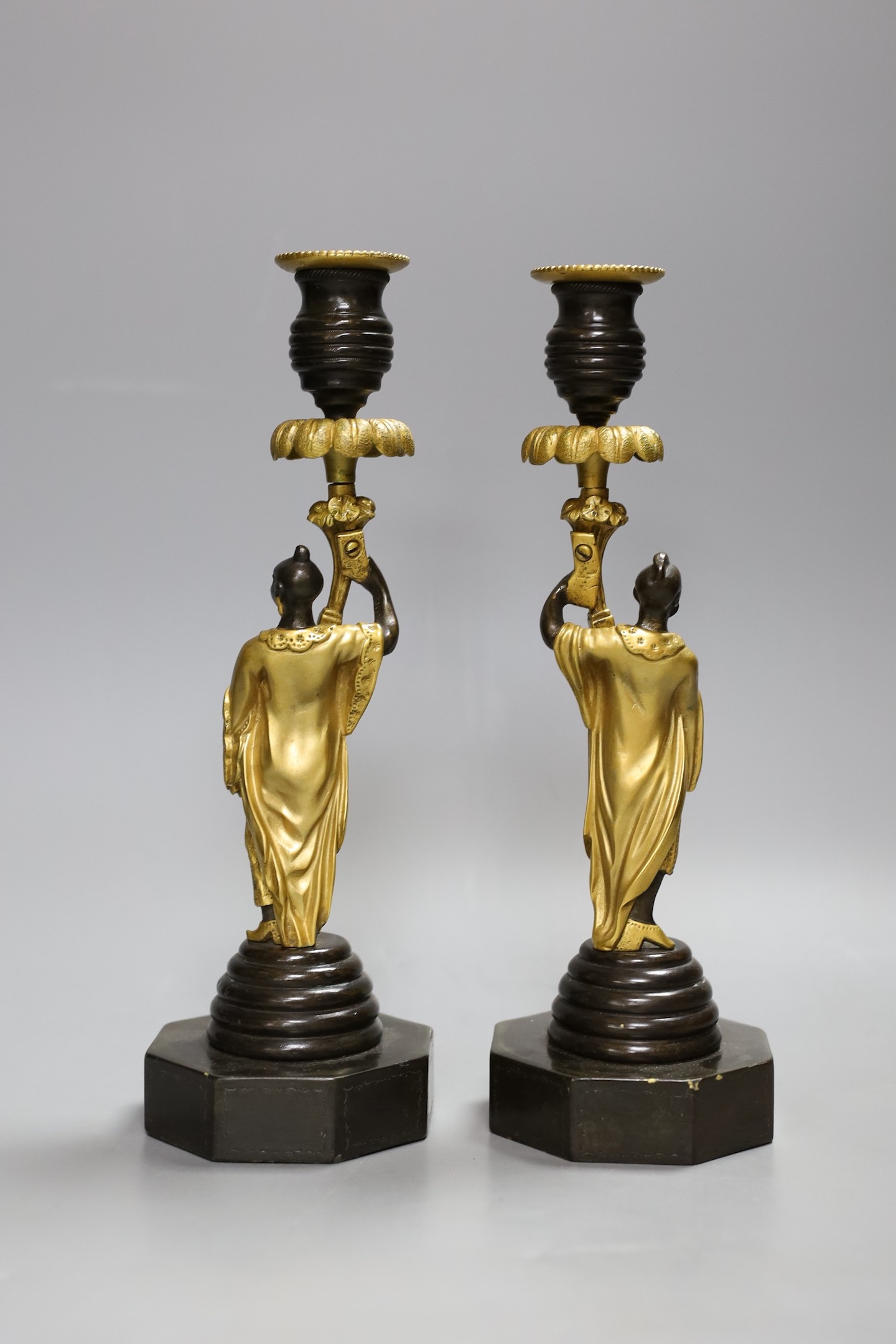 A pair of Eastern style bronze and ormolu figural candlesticks, 27cm